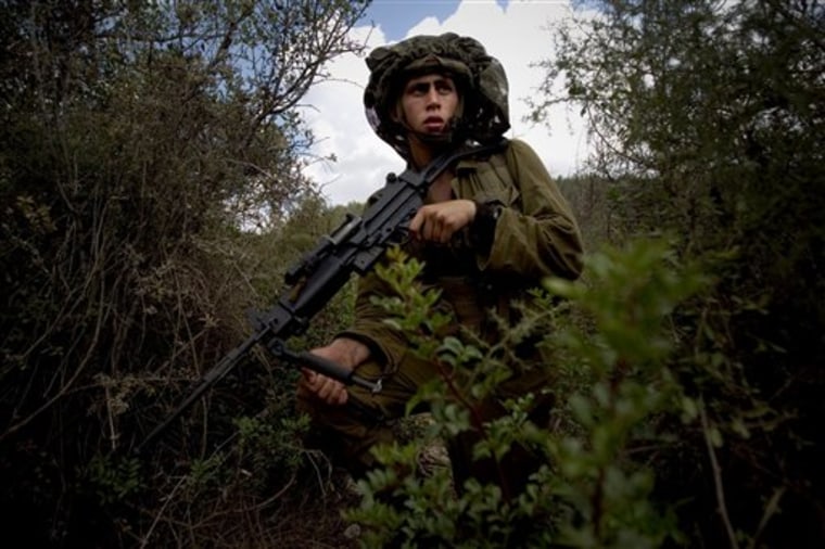 An Israeli soldier from the Golani Brigade takes position July 21 during training in a forest simulating military posts in south Lebanon, at the Elyakim training grounds in northern Israel. With tensions mounting along their shared border, Israel's military says Hezbollah is moving fighters and weapons into the villages of south Lebanon, building up a secret network of arms warehouses, bunkers and command posts in preparation for war.